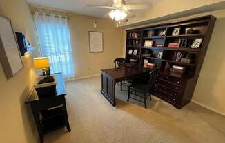 a home office with a desk and a bookcase