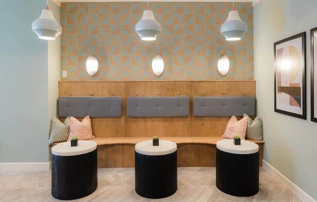 A room with a bench and three tables.