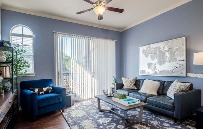 Living room with blue walls, leather sofa and balcony light