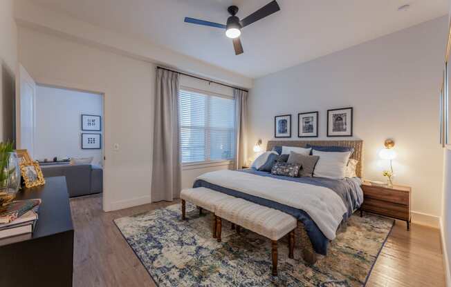 Studio Apartments in Downtown Dallas, TX- 4600 Ross- Bedroom with Wood-Style Flooring, a Ceiling Fan, and a Large Window