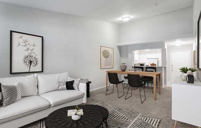 A living room with a white couch, a coffee table, and a dining table with chairs.