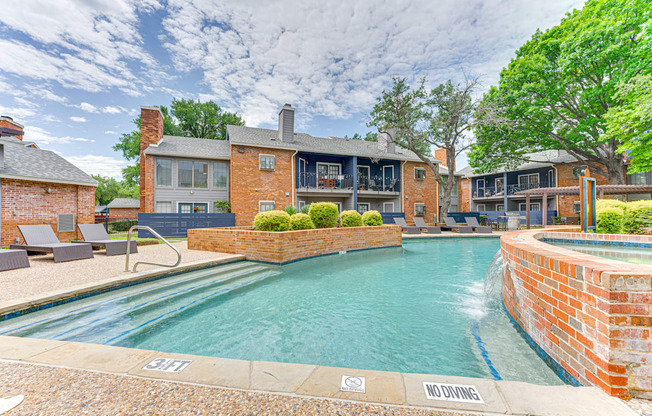 A pool surrounded by a brick wall with a "No Diving" sign.