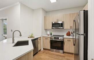 A modern kitchen with wooden cabinets and stainless steel appliances.