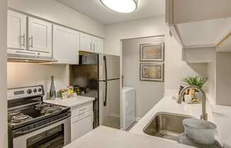 a kitchen with white cabinetry and stainless steel appliances at Hunters Chase Apartments, Virginia