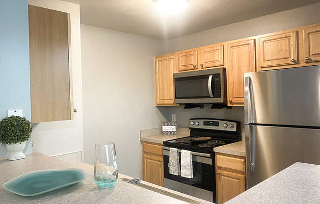 A kitchen with a stove, microwave, and refrigerator.