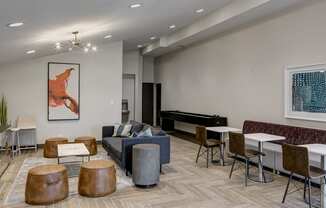 a living room with couches tables and chairs and a piano