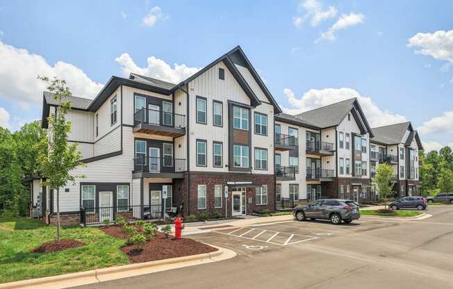 an apartment building with a red fire hydrant on the corner of a street