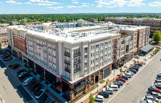 a large white building with a white roof and a lot of cars parked in front of it