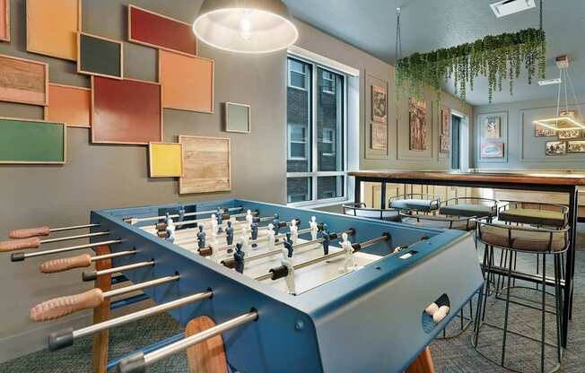 A foosball table is in the middle of a room with a blue wall.