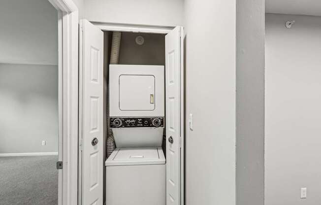 A white washing machine is installed in a small laundry room.