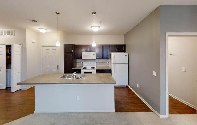 an empty kitchen with a sink and a refrigerator