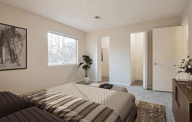 A bedroom with a large bed and a painting on the wall.