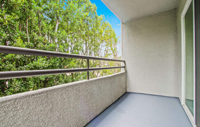 a balcony with a view of trees and a blue sky