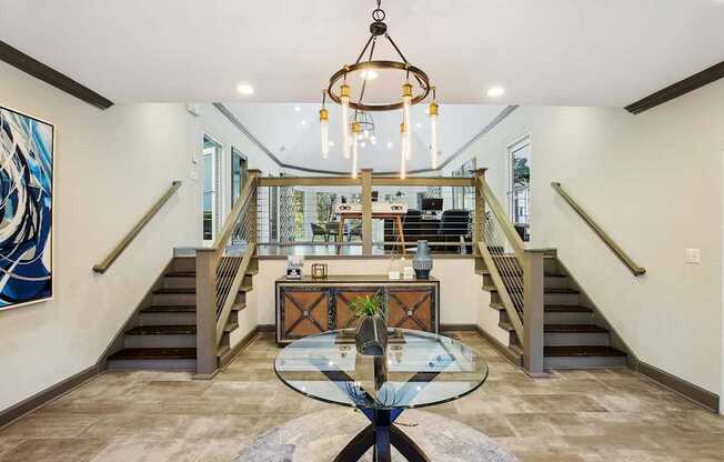 the entryway of a house with a glass table and stairs