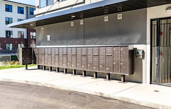 A long row of mailboxes are lined up on the sidewalk.