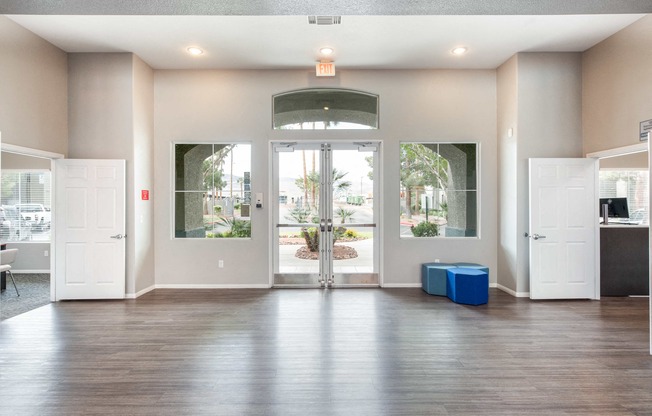 an empty living room with white doors and a hard wood floor