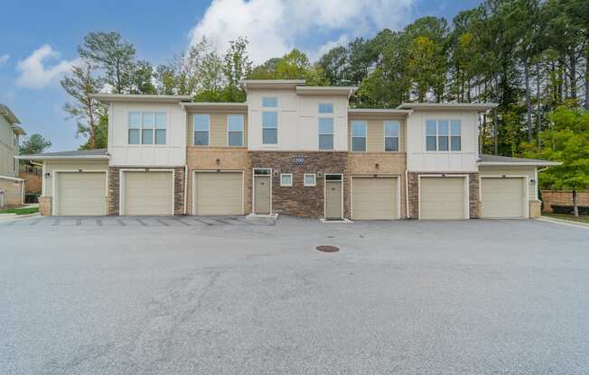 a large white and tan house with garage doors