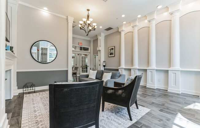 a living room with white pillars and a table and chairs