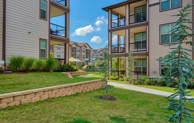 Exterior photo of Parc at Bentonville with trees and grass and building