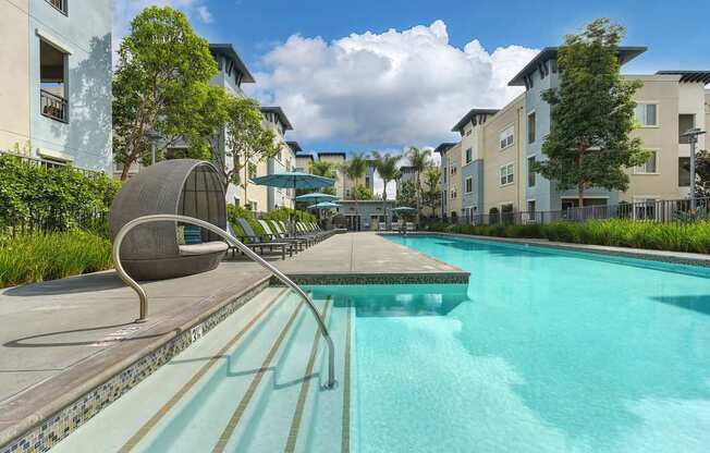 A swimming pool with a diving board and a sun lounger.