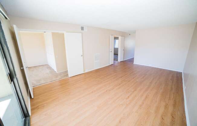 the living room and dining room of an empty house with wood floors