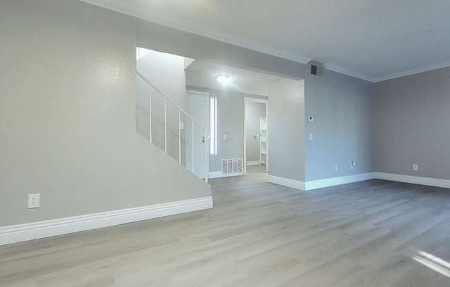 the living room and dining room of an empty apartment