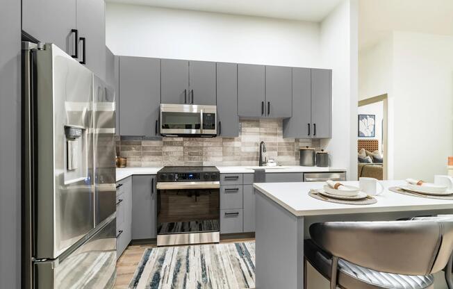 Gourmet kitchens showcase quartz countertops, custom cabinetry, stainless steel appliances, and a stylish tile backsplash.