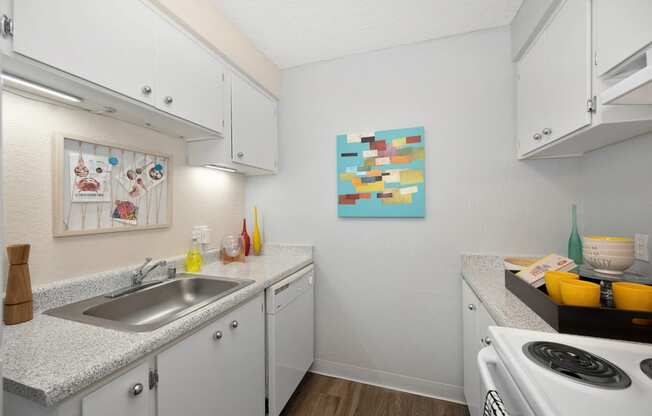 a kitchen with white cabinets and a sink and a stove