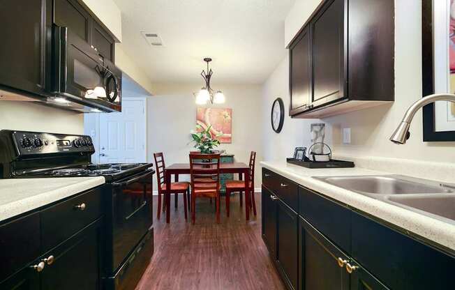 A kitchen with dark wood cabinets and a white countertop.