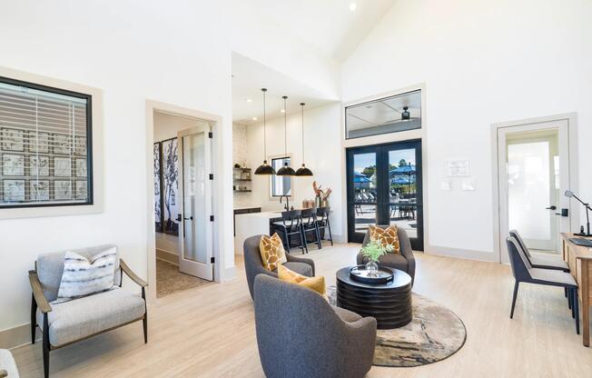 The resident clubhouse features comfortable lounge seating, coworking space, and vaulted ceilings, creating a versatile environment for socializing, remote work, and everyday connection.