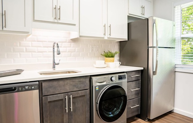 a kitchen with white cabinets and stainless steel appliances