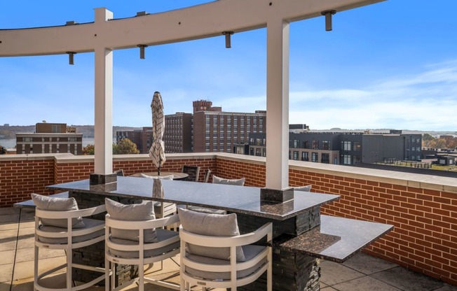 a patio with a table and chairs on top of a roof