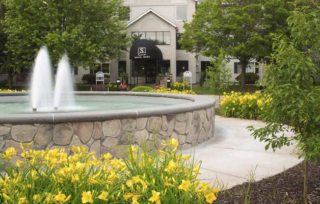 Large water fountain in front of the entrance to the apartment lobby