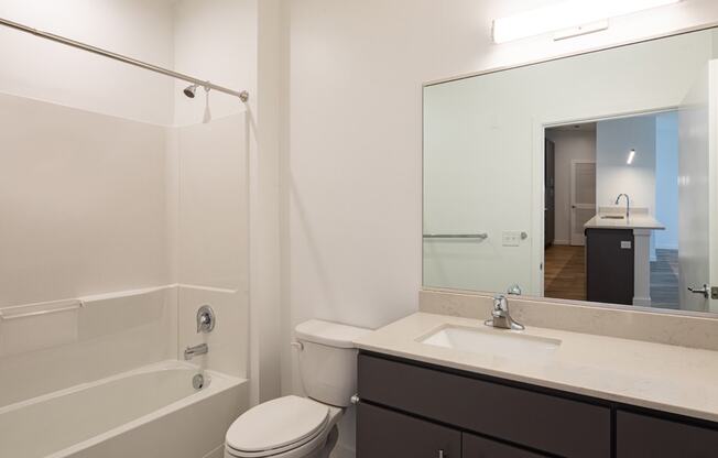 a bathroom with a shower sink and toilet and a mirror