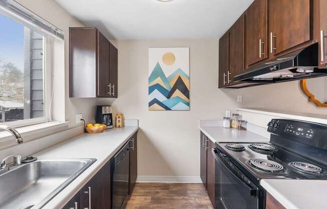 A kitchen with a stove top oven and a painting on the wall.