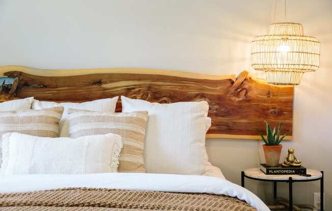 a bed with white pillows and a wooden headboard and two lamps at Tapestry at Hollingsworth Park