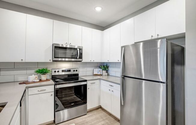 a kitchen with stainless steel appliances and white cabinets