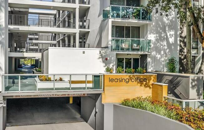 A modern building with a leasing office in front.