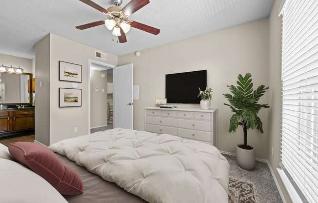 a bedroom with a large bed and a ceiling fan