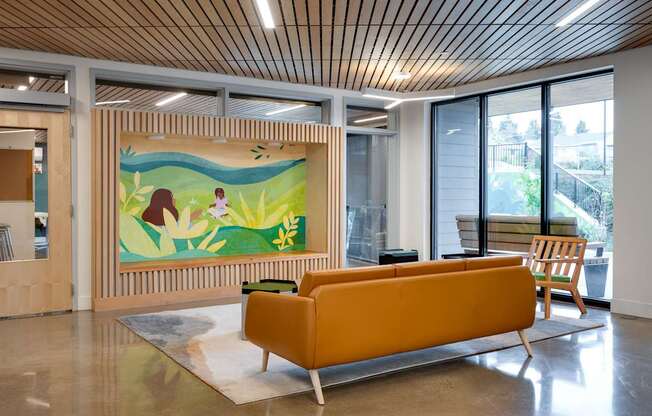 a living room with a yellow couch and a painting on the wall