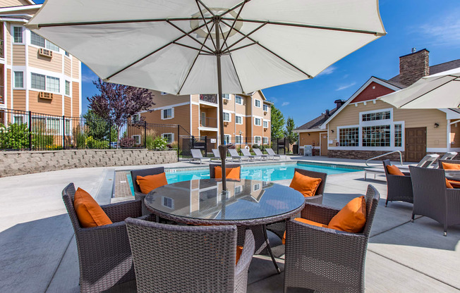 our apartments have a large pool and patio with chairs and umbrellas. Poolside lounge area