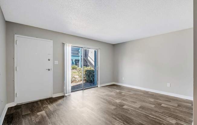 Model living room with sliding door leading to patio at Oasis at Bayside in Largo, FL.