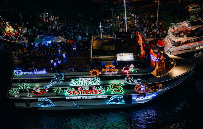 A boat with the words "Savages Slaggars" written on it is docked at night.