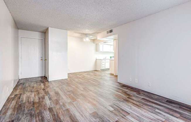 A room with wooden flooring and white walls.