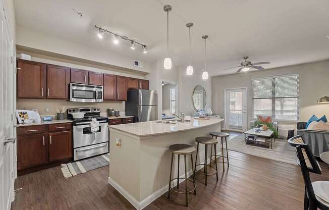 A kitchen with a white island and dark wood cabinets.