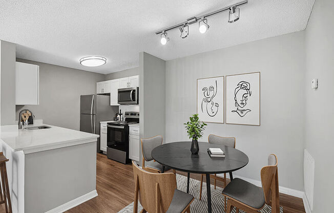 Model Dining Room and Kitchen Area with Wood-Style Flooring at Fountains Lee Vista Apartments in Orlando, FL.