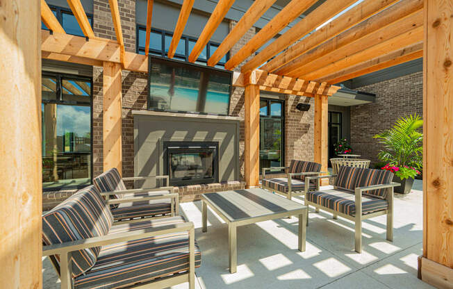 a covered patio with chairs and a fireplace
