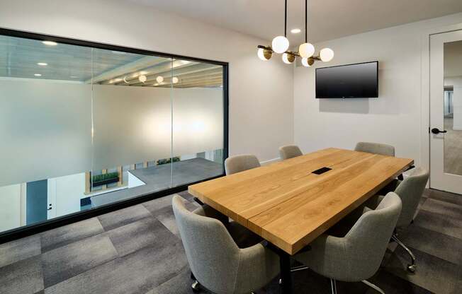 A conference room with a long table and chairs.