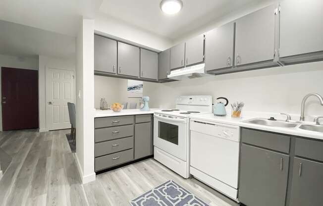 Kitchen with wood-like flooring, gray top, and bottom cabinets, looking down hallway into the dining area.at Summit, Idaho