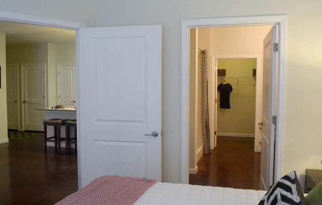 A man is standing in a hallway with a white door.